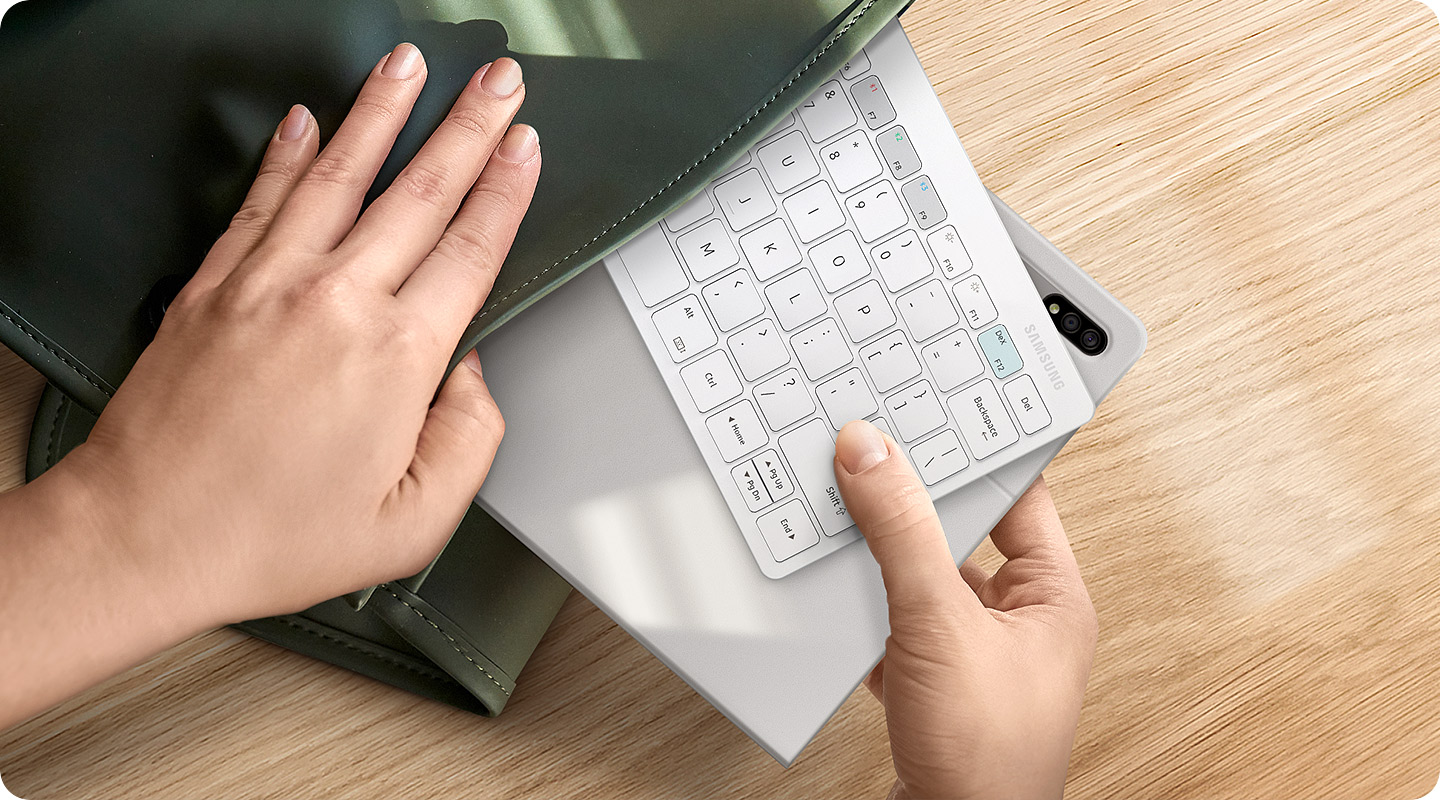 A user removes their Smart Keyboard Trio 500 and Galaxy Tab devices from their handbag